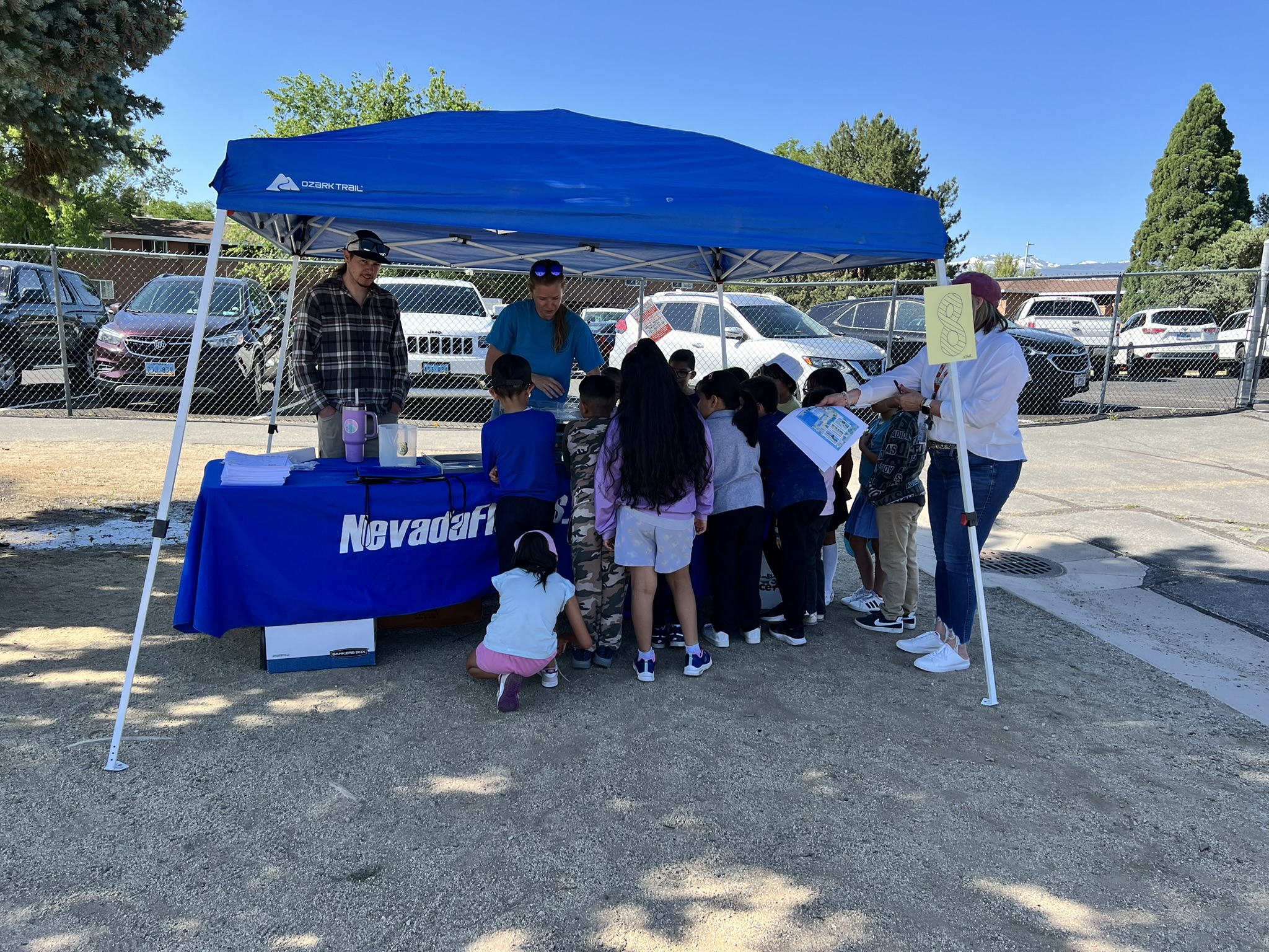 Sarah and Andy demonstrate the floodplain model simulator at Waterpalooza for a group of school children.